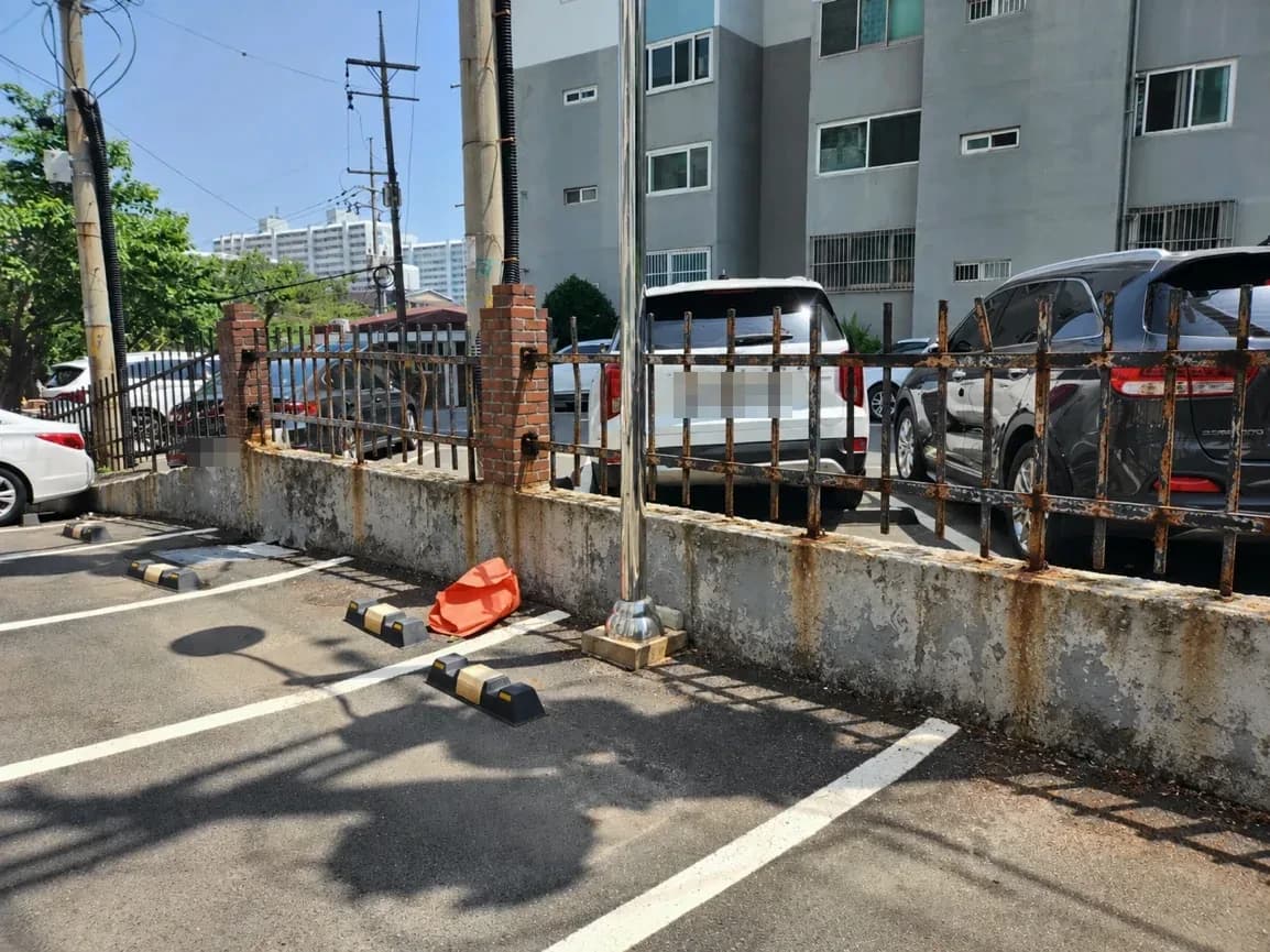 녹슬고 휜 기존 난간과 얼룩진 경계 담장.